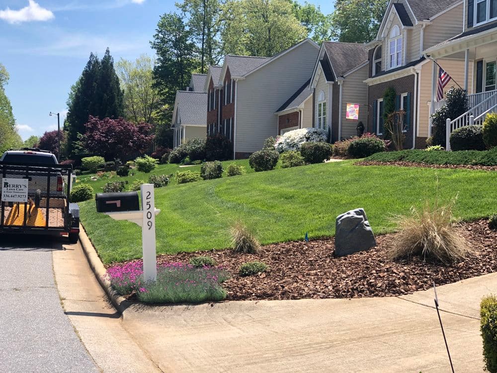 Residential neighborhood with well-maintained lawns, mailbox at 2509, and parked trailer.